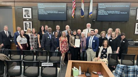 Photo of 26 people at the City Council meeting showing a resolution