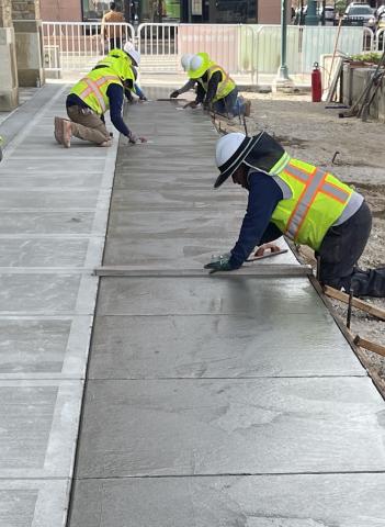 Workers begin smoothing the concrete expansion of the Tejon St. sidewalk