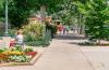 Pedestrians walk and sit downtown near a bed of flowers