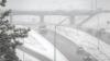 Cars drive on the road during a heavy snow storm.